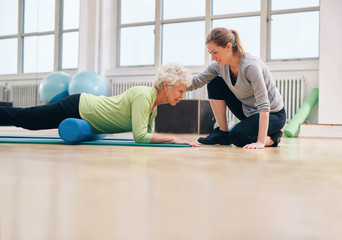 Physical therapist helping elderly woman in her workout