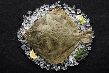 Gordijnen Verse tarbotvis op ijs op een zwarte stenen tafelbladweergave © nioloxs
