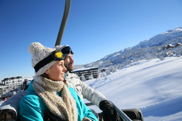 Couple sitting on ski resort chairlift