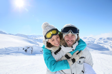 Man holding girlfriend on his back at the top of mountain
