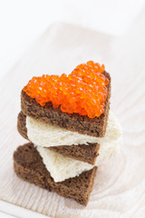 toast with red caviar in heart shape, vertical