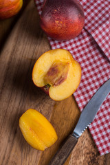 Organic fresh nectarine peach cut on rustic board