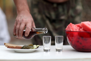 Person filling glasses of brandy