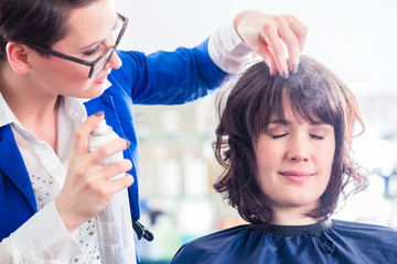 Friseur frisiert Frau die Haare im Friseursalon