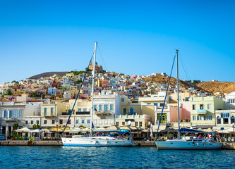 Fototapeta na wymiar Greek island with colorful houses and yachts.