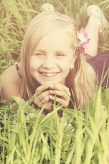 Naklejka premium Carefree smiling blonde girl on sunny grass