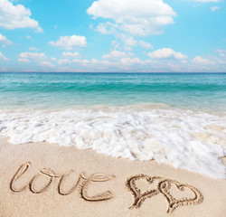 Fototapeta na wymiar Hearts drawn on the beach sand.