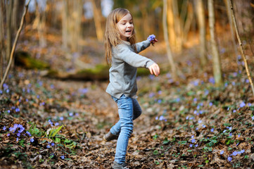 Adorable girl picking the first flowers of spring