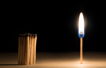 Crowd of burnt  matches standing before match on fire concept of