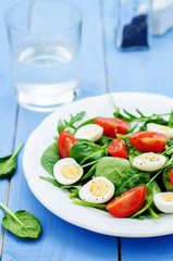 salad with arugula, spinach, tomatoes and eggs.