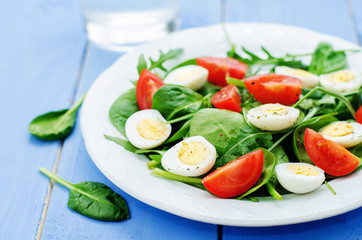 salad with arugula, spinach, tomatoes and eggs.