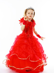 Cute little princess dressed in red  with crown on her head posi