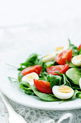 salad with arugula, spinach, tomatoes and eggs