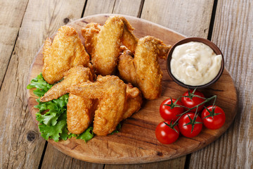 Fried chicken wings with sauce and tomatoes