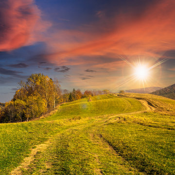 path on hillside meadow in mountain at sunset
