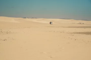 Foto op Plexiglas Sand dune landscape with couple walking to the horizon. Clear bl © ysbrandcosijn