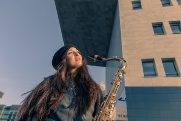 Beautiful young woman with her saxophone