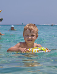 Fototapeta na wymiar Happy child swimming in the sea.