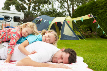 Father With Children Relaxing On Camping Holiday