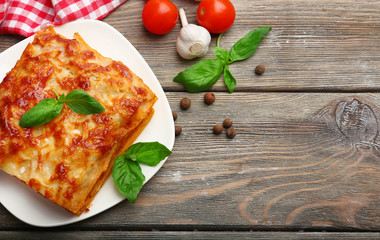 Portion of tasty lasagna on wooden table