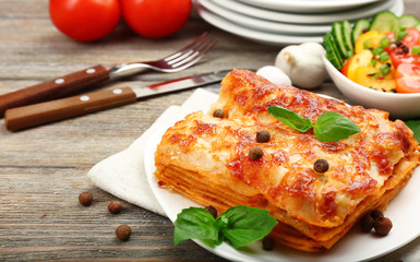Portion of tasty lasagna on wooden table