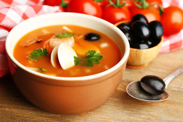 Tasty soup with shrimps, mussels, tomatoes and black olives in