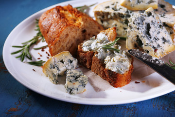 Blue cheese with sprigs of rosemary, bread and nuts