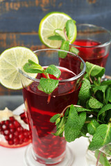 Pomegranate drink in glasses with mint and slices of lime