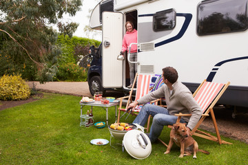 Couple In Van Enjoying Barbeque On Camping Holiday © micromonkey