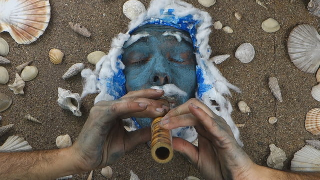 Blue sea man playing flute underwater