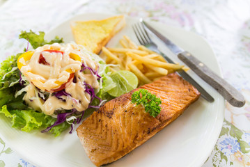 grilled salmon steak with french fried and vegetable salad