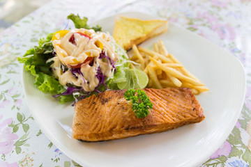 grilled salmon steak with french fried and vegetable salad