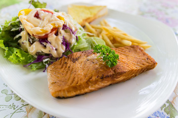 grilled salmon steak with french fried and vegetable salad