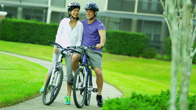 Happy Multi Ethnic Couple Activity Cycling Together Outdoors
