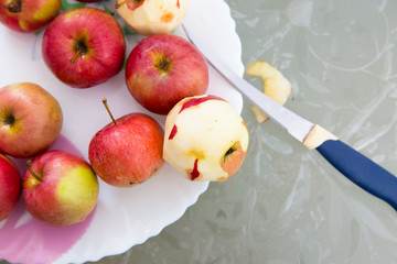 Peeled apple and knife on plate