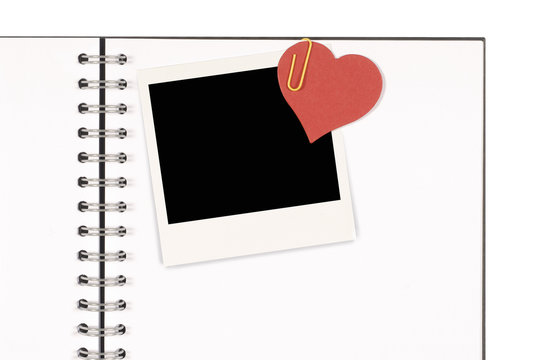 Notebook with polaroid photo frame and red paper heart valentine or love memory concept photo