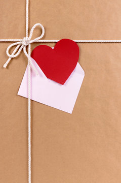 Brown paper package parcel background with red valentine heart shape card gift tag or love message photo