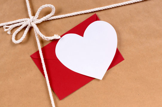 Brown paper package parcel background with white valentine heart shape card gift tag or love message photo