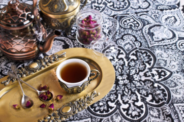 Obraz na płótnie Canvas Tea roses in a beautiful Cup with Oriental motifs