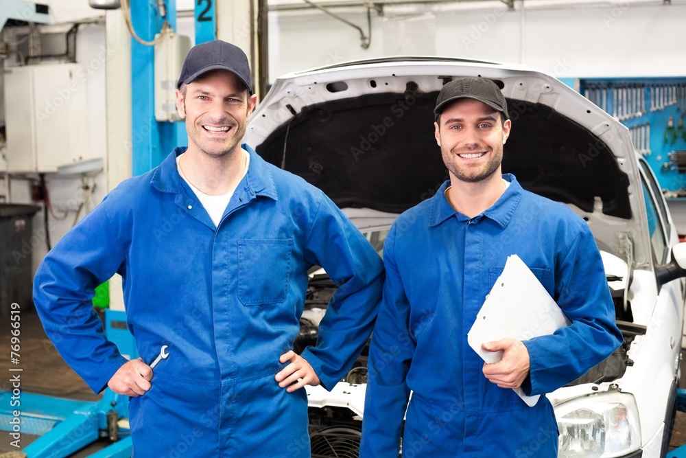 Poster team of mechanics smiling at camera