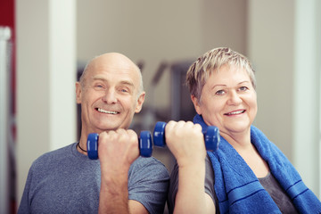 älteres paar trainiert mit kleinen hanteln im fitnessraum