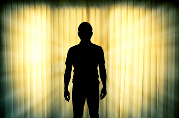 Silhouette of man standing with light ray effect background