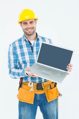 Happy construction worker showing laptop