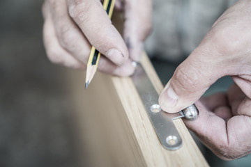 Closeup of carpenter with pencil working on door
