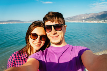 Happy loving couple taking self-portrait on beach
