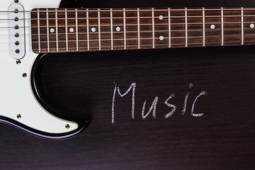 the word "music" against the backdrop of guitar
