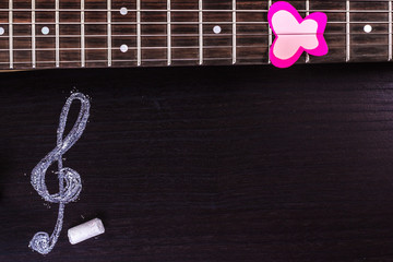 Electric guitar with treble clef on dark background