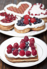 Waffle cookies in the form of hearts decorated with whipped crea