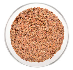 Brown flax seeds in glass bowl isolated.