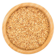Golden flax seeds in wooden bowl isolated.